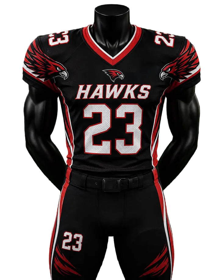 A black football uniform set displayed on a black mannequin torso against a green grass-like background. The jersey and pants are black with red and white accents, featuring the word HAWKS across the chest, the number 23 on the front and thigh, eagle head graphics on the shoulders, and a hawk logo on the chest.