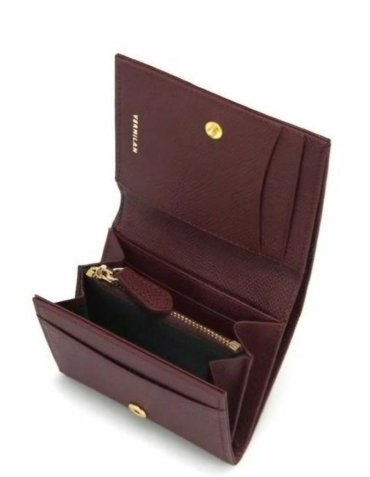 A burgundy leather wallet shown open, displaying its interior compartments, card slots, a zippered pocket, and gold-tone hardware. The brand name 'VERSACE' is subtly embossed on the inside flap.